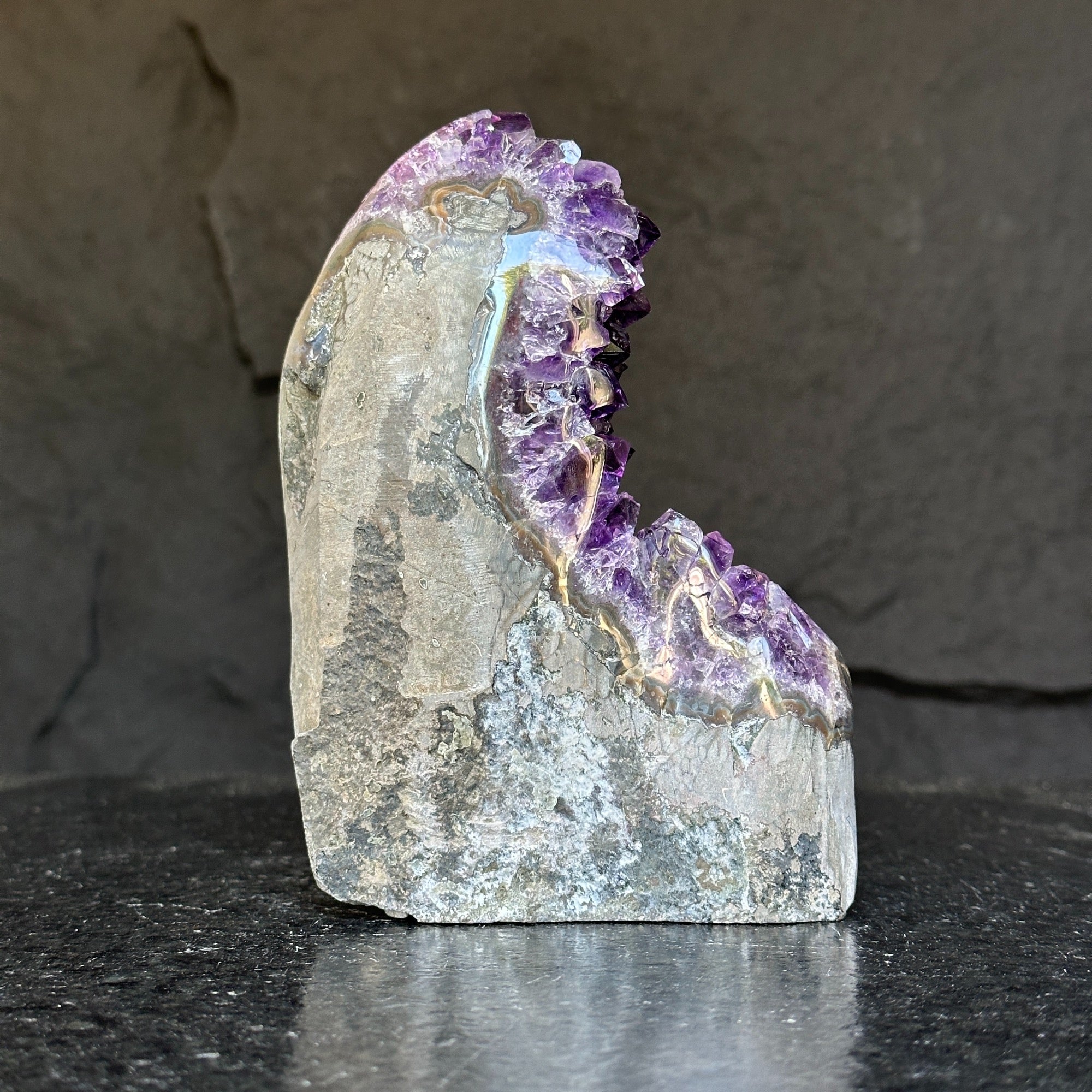 Extra large Uruguayan amethyst geode with deep purple crystals and gray agate formations.