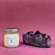 Jar of candle with a crystal on a pink background
