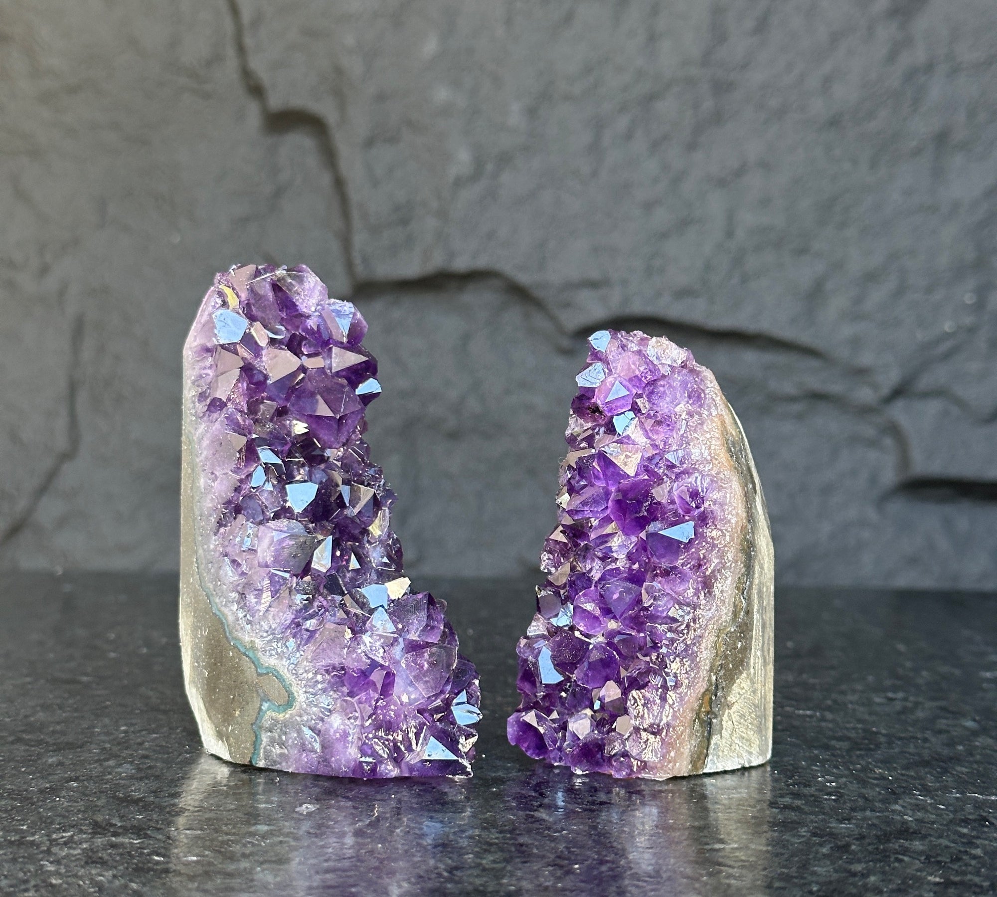 Two deep purple Uruguayan amethyst geode clusters, 3-inch high, on a dark surface.