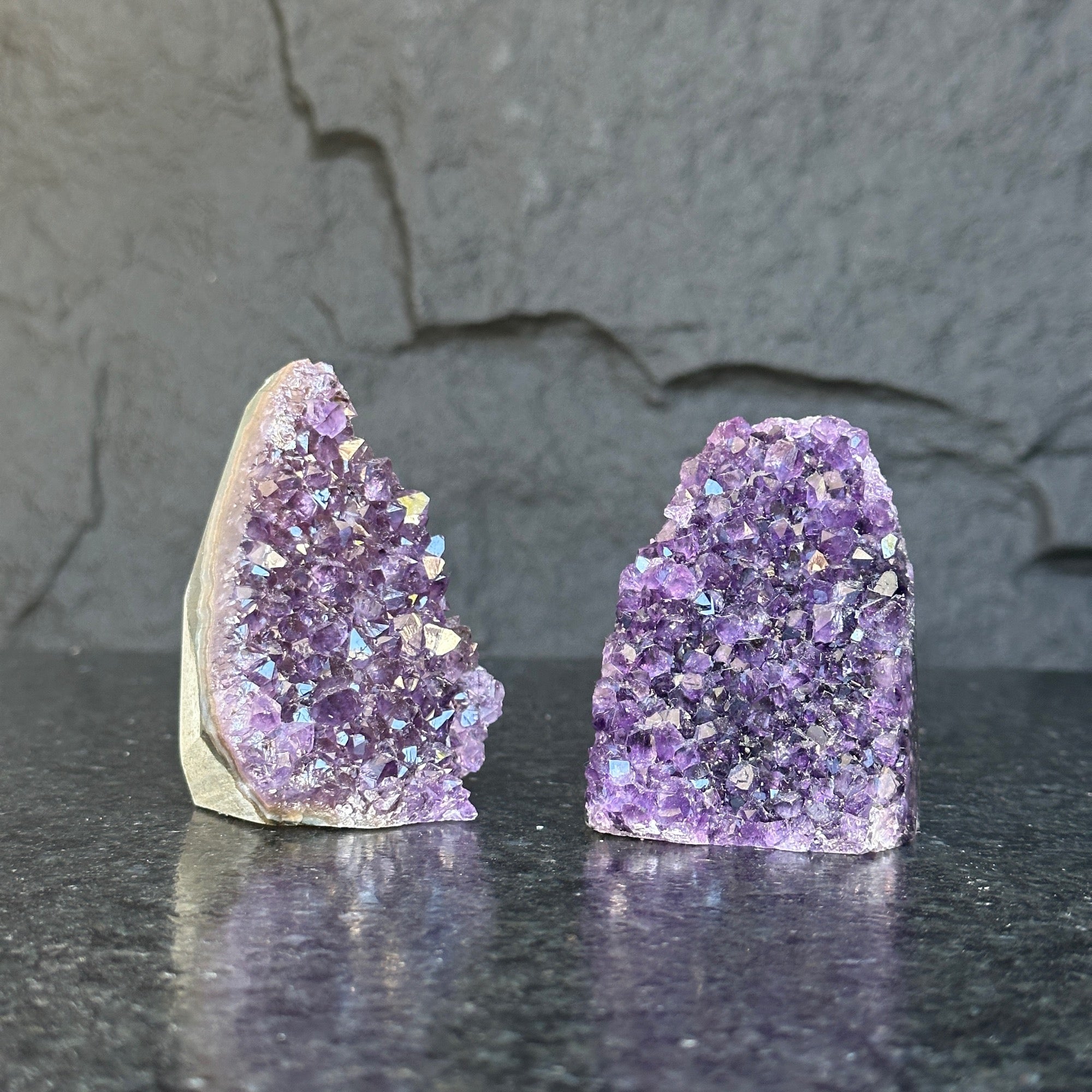 Two raw Uruguayan amethyst geodes, 3-inch high, with deep purple crystals on a dark background.