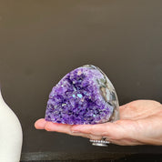 Self-standing cut base amethyst crystal cluster, 3x3 inch, 1.1 lb, held in a hand.