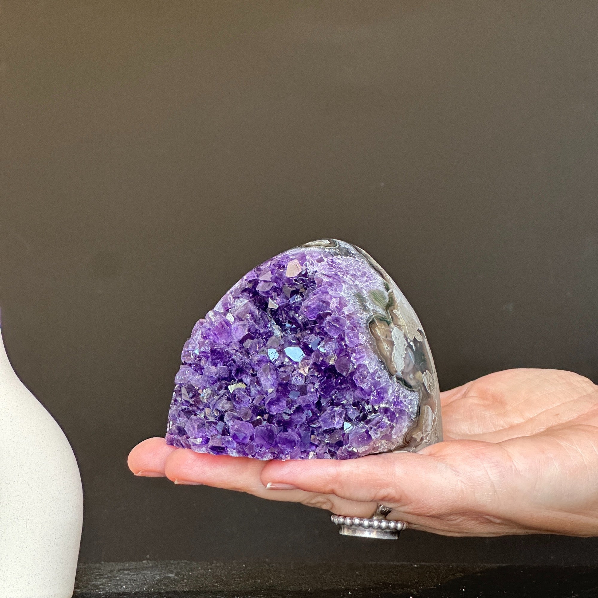 Self-standing cut base amethyst crystal cluster, 3x3 inch, 1.1 lb, held in a hand.