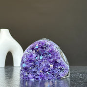 Self-standing, cut base amethyst crystal cluster with vibrant purple points on a dark surface.
