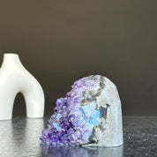 Self-standing, cut base amethyst crystal cluster with vibrant purple points and a gray exterior.