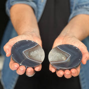 Two hands holding agate stones against a blurred background