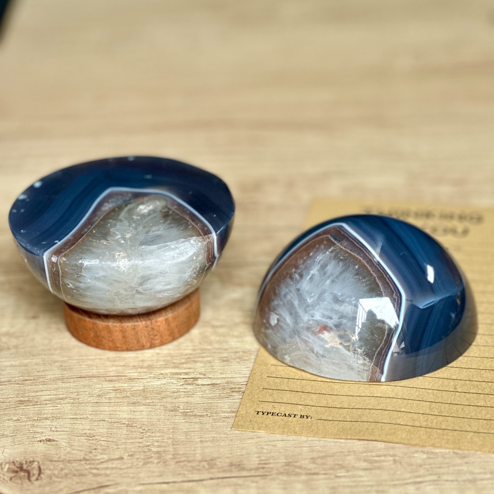 Two stone geode objects on a wooden surface