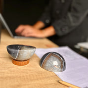 Two decorative items on a wooden surface with a blurred person in the background.