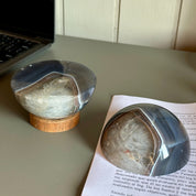 Two agate stones on a desk with a laptop and book in the background.