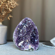 Deep purple amethyst geode cluster with sparkling natural crystals.