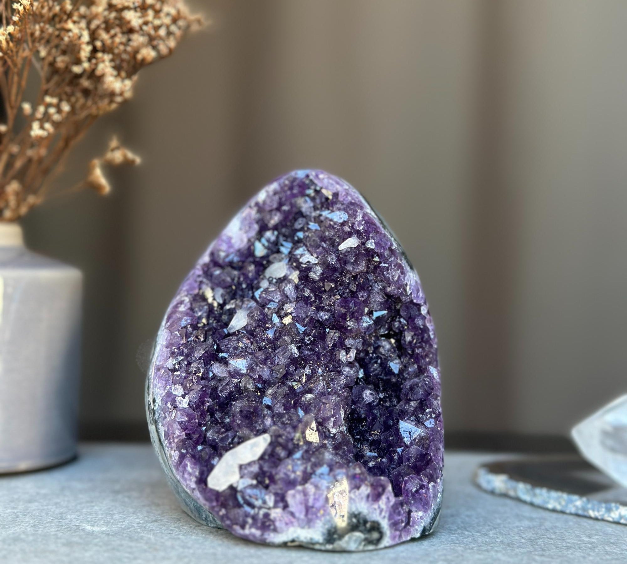 Deep purple amethyst geode cluster with sparkling natural crystals.