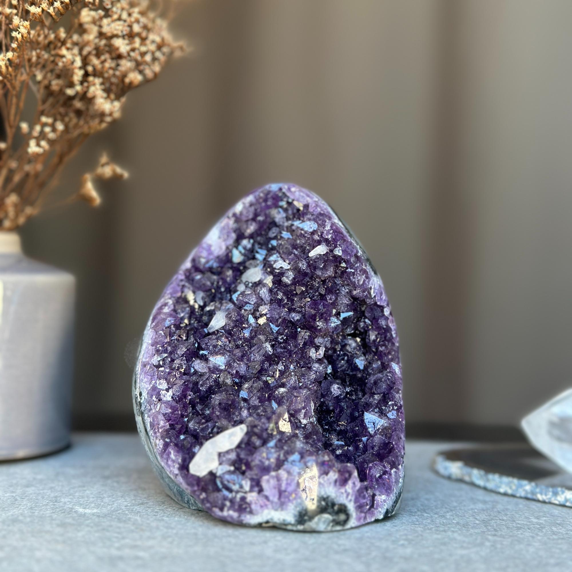 Deep purple amethyst geode cluster with sparkling natural crystals.