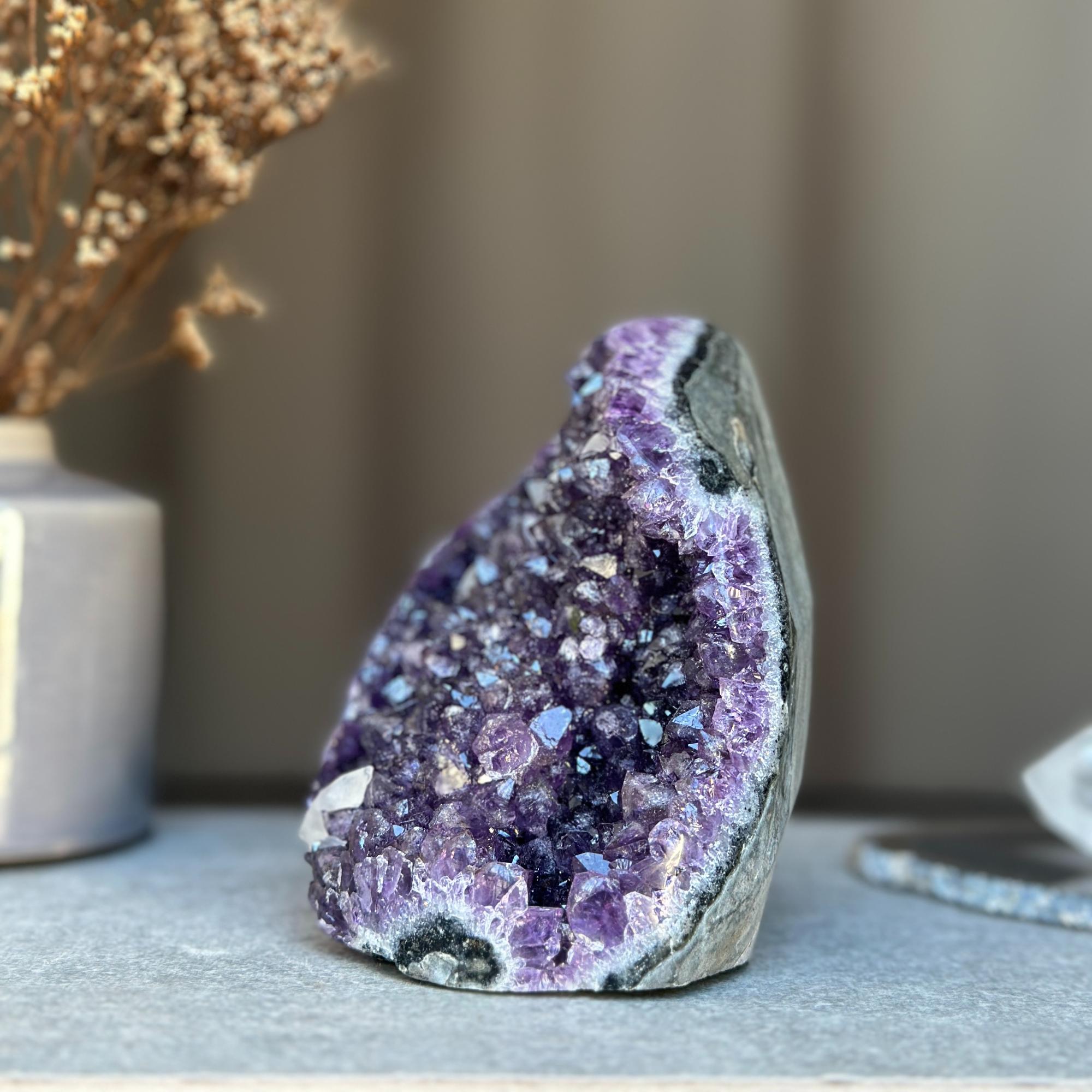 Vibrant deep purple amethyst geode cluster from Uruguay, featuring sparkling crystals.