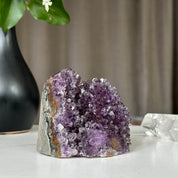 Deep purple Uruguayan amethyst geode cluster, 3x3 inches, on a white surface.