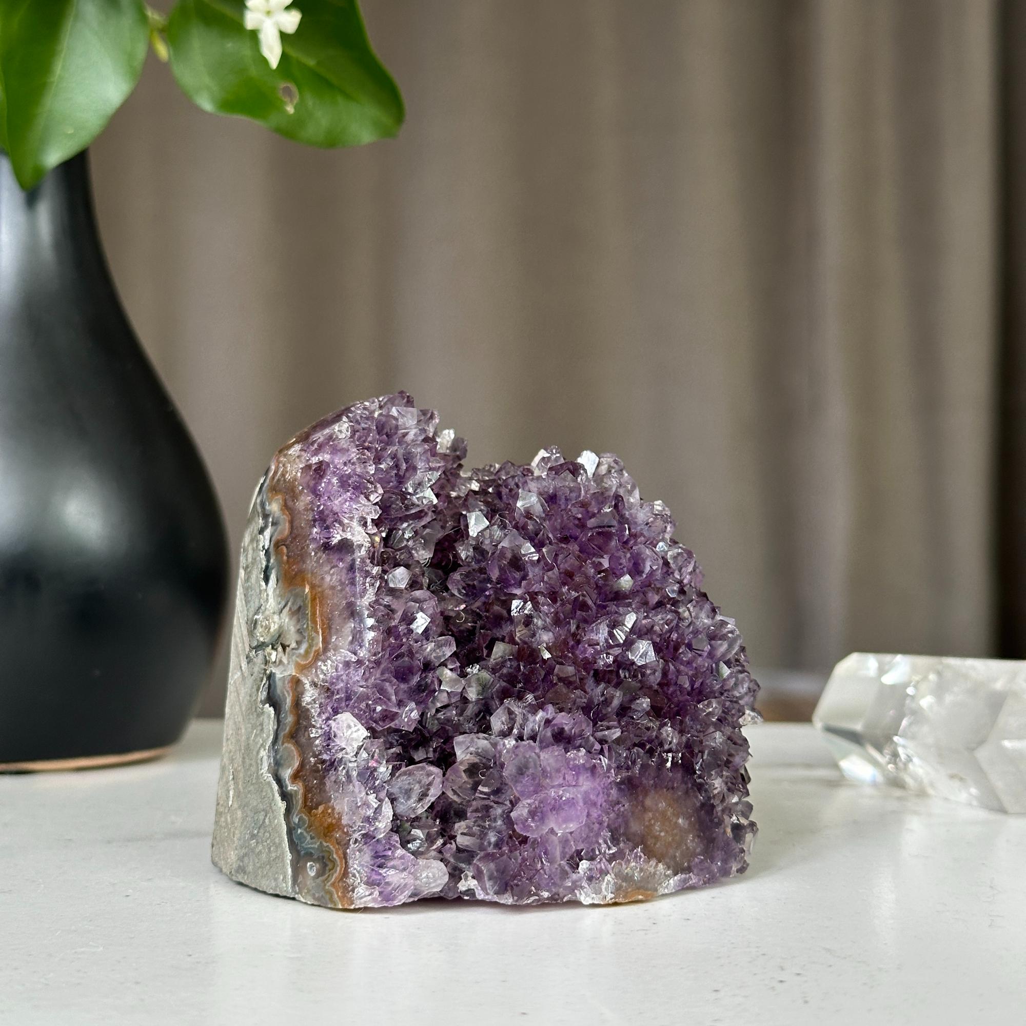 Deep purple Uruguayan amethyst geode cluster, 3x3 inches, on a white surface.
