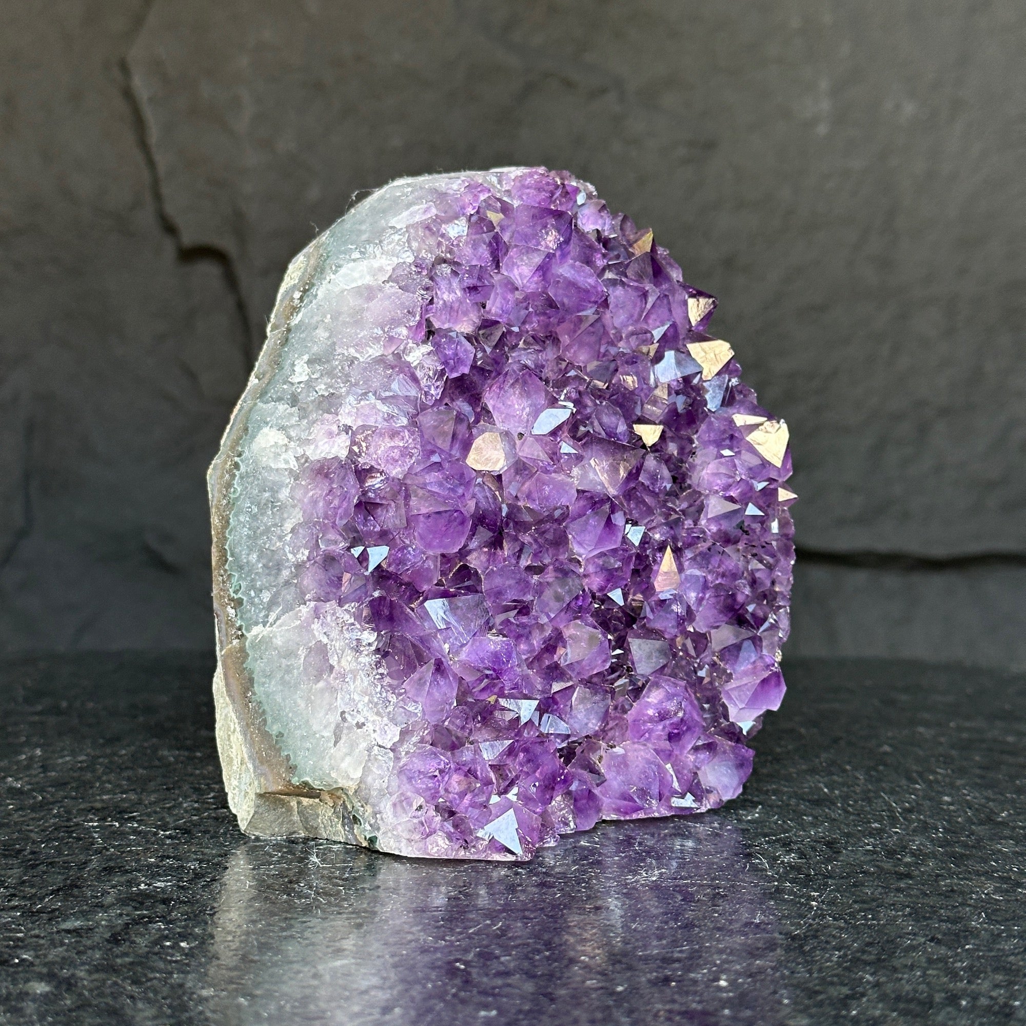 Deep purple Uruguayan amethyst cathedral geode with sparkling crystal points and calcite formation.