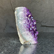 Deep purple Uruguayan amethyst cathedral geode with sparkling crystal points and calcite formation.