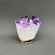 Vibrant deep purple amethyst geode with sparkling crystal points and a natural white base.
