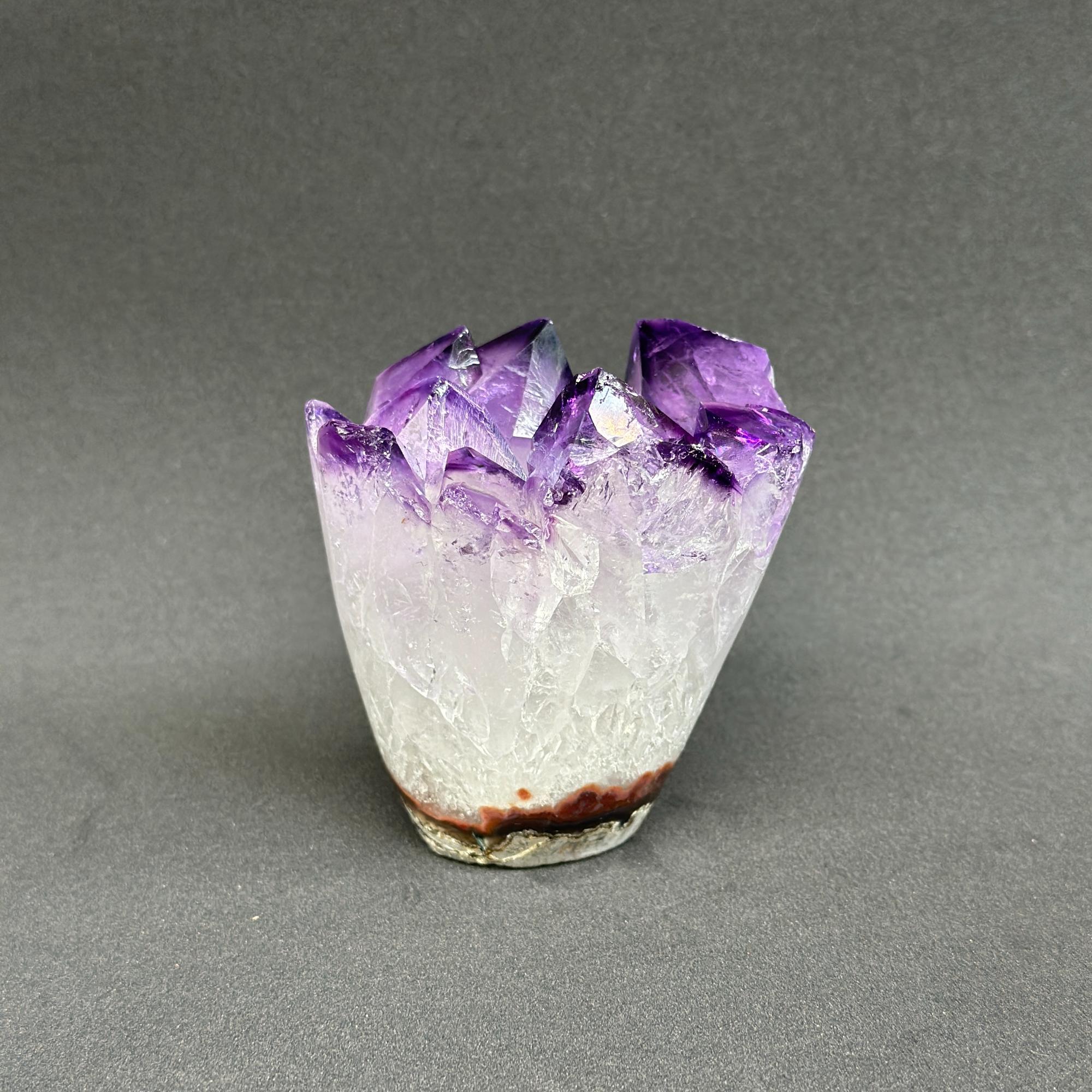 Vibrant deep purple amethyst geode with sparkling crystal points and a natural white base.