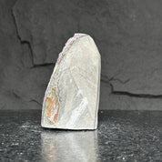 Extra large natural amethyst cluster, 5-inch tall purple crystal geode with rough grey stone exterior.