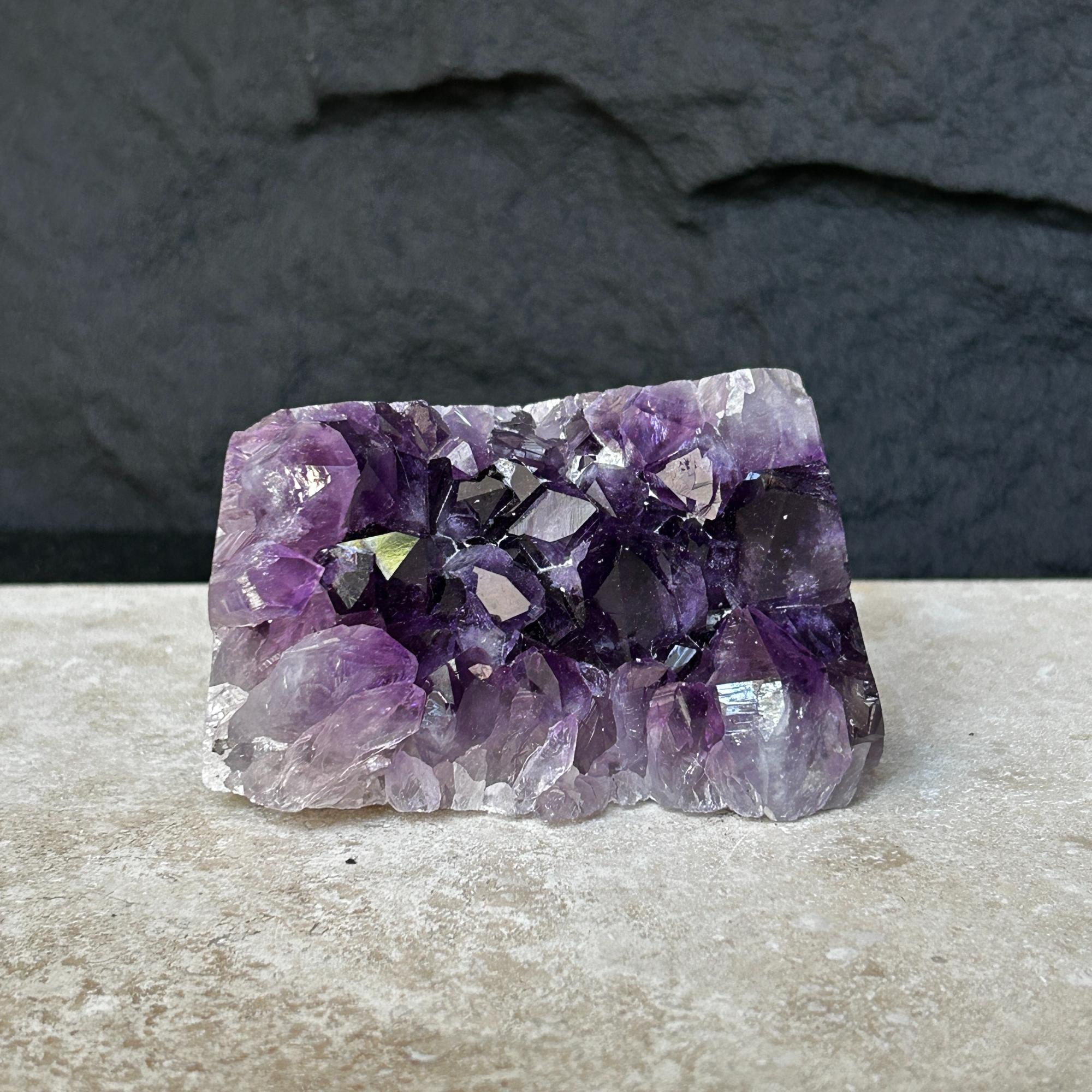 Flat, vibrant deep purple raw amethyst crystal cluster, 0.9 lb, on a light surface.