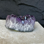 Flat, raw Uruguayan amethyst crystal cluster with deep purple points and a frosted base.