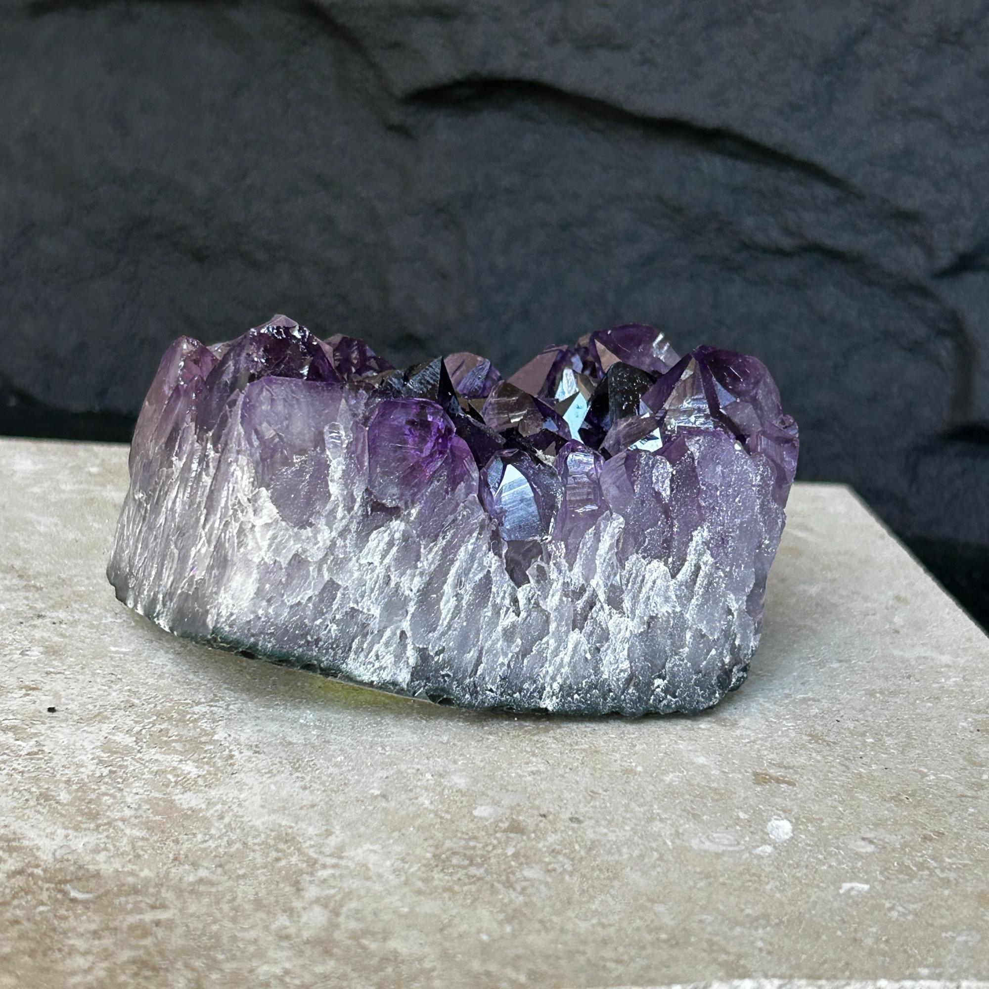Flat, raw Uruguayan amethyst crystal cluster with deep purple points and a frosted base.