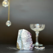 Purple and white Galaxy Amethyst geode, 3.5 inches tall, with a clear glass in the background.