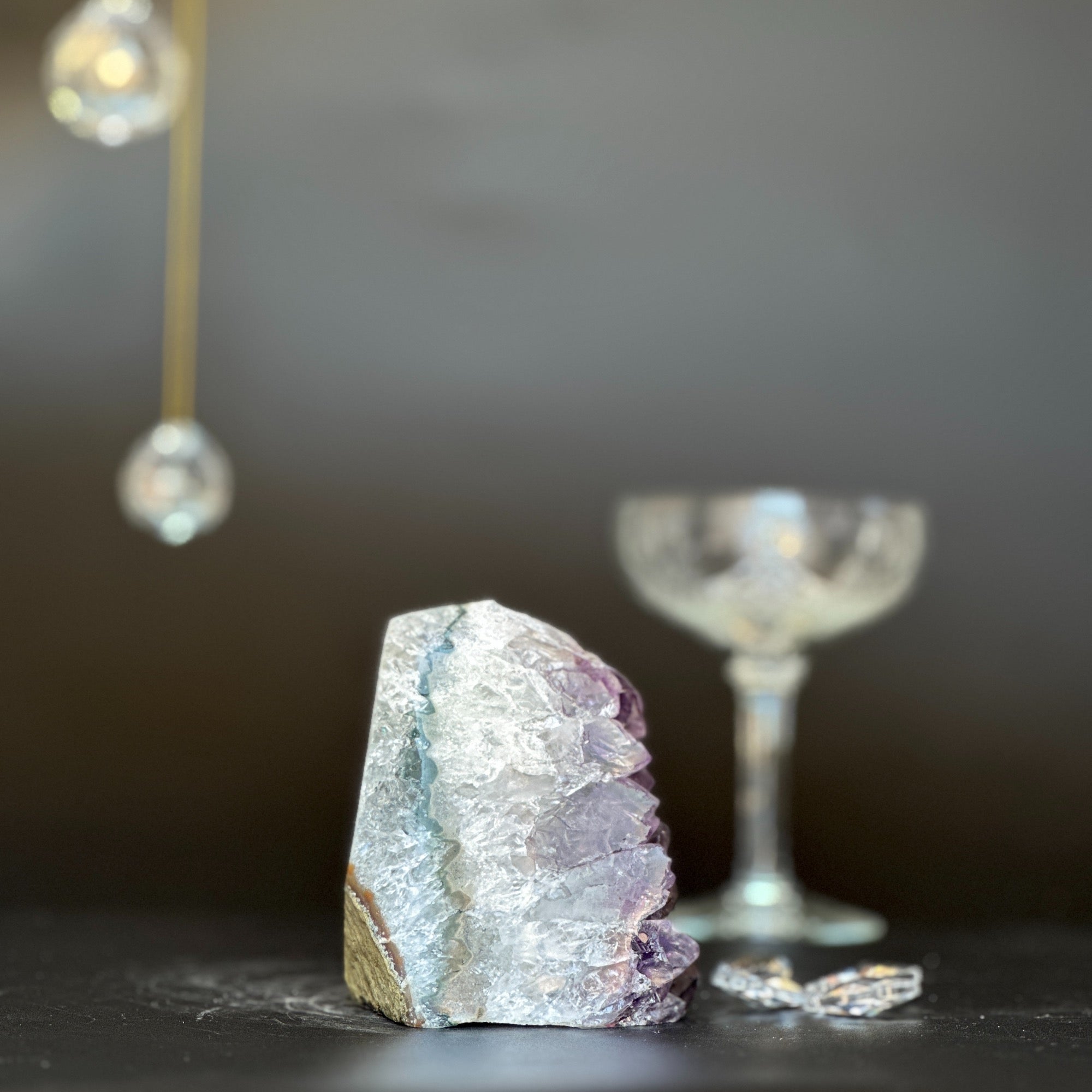 Purple and white Galaxy Amethyst geode, 3.5 inches tall, with a clear glass in the background.