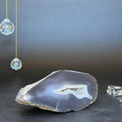 Polished gray agate geode slice with white crystal cave and subtle banding.