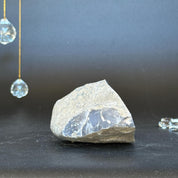 Rough gray agate stone with a smooth, light purple interior on a dark surface.