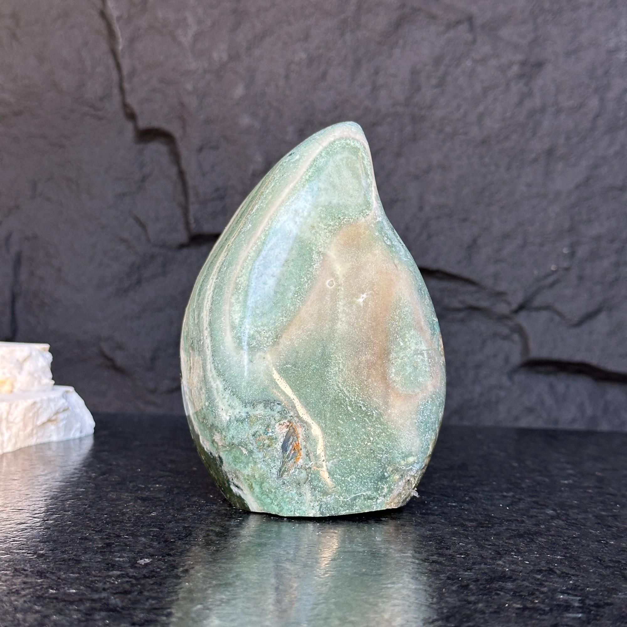 Green jasper flame gemstone, 5.5-inch tall, with natural swirling patterns on a dark background.