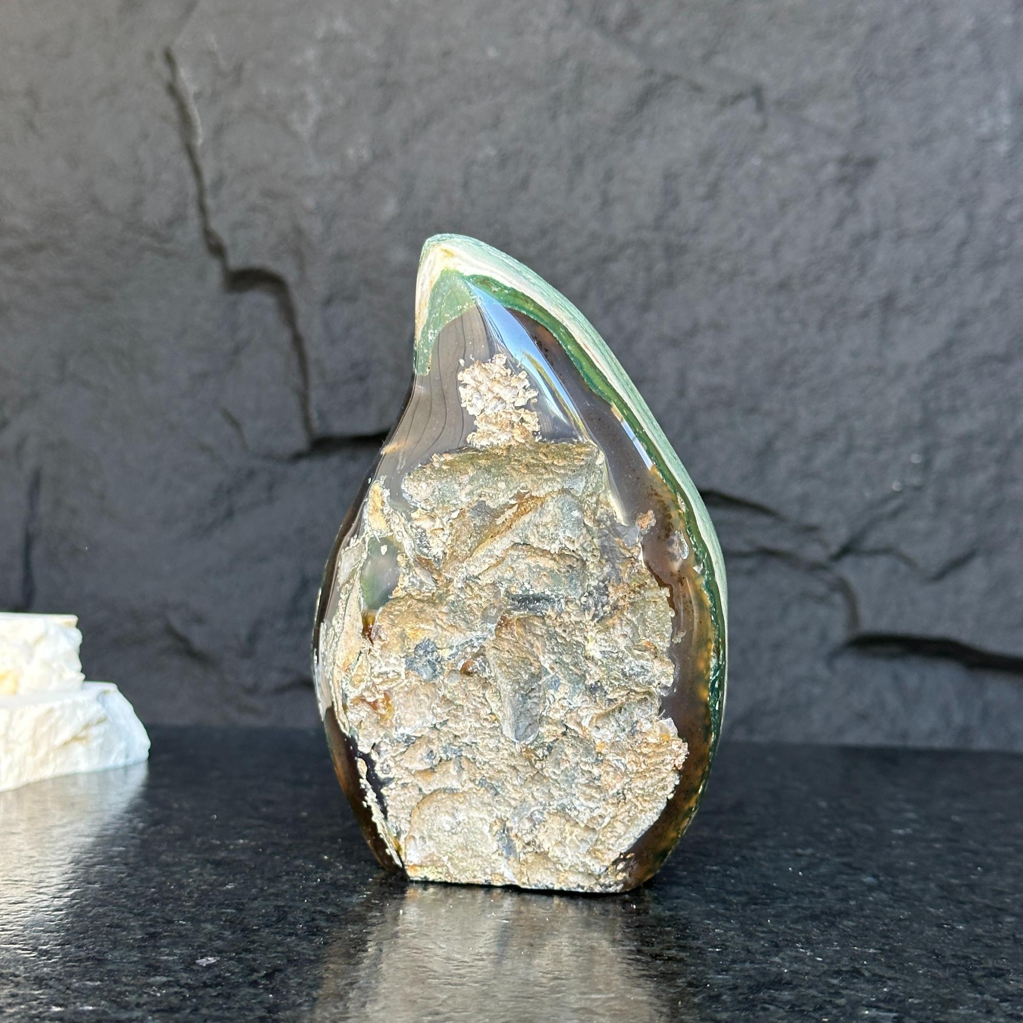 Green Jasper Flame gemstone, a polished, teardrop-shaped crystal with rough, textured brown and tan inclusions.