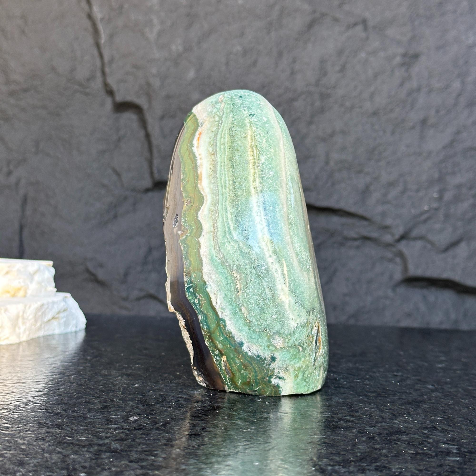 Green Jasper Flame gemstone, 5.5-inch tall, with natural striped patterns on a dark background.