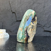 Polished green jasper flame gemstone, 5.5-inch tall, with natural brown and black inclusions.