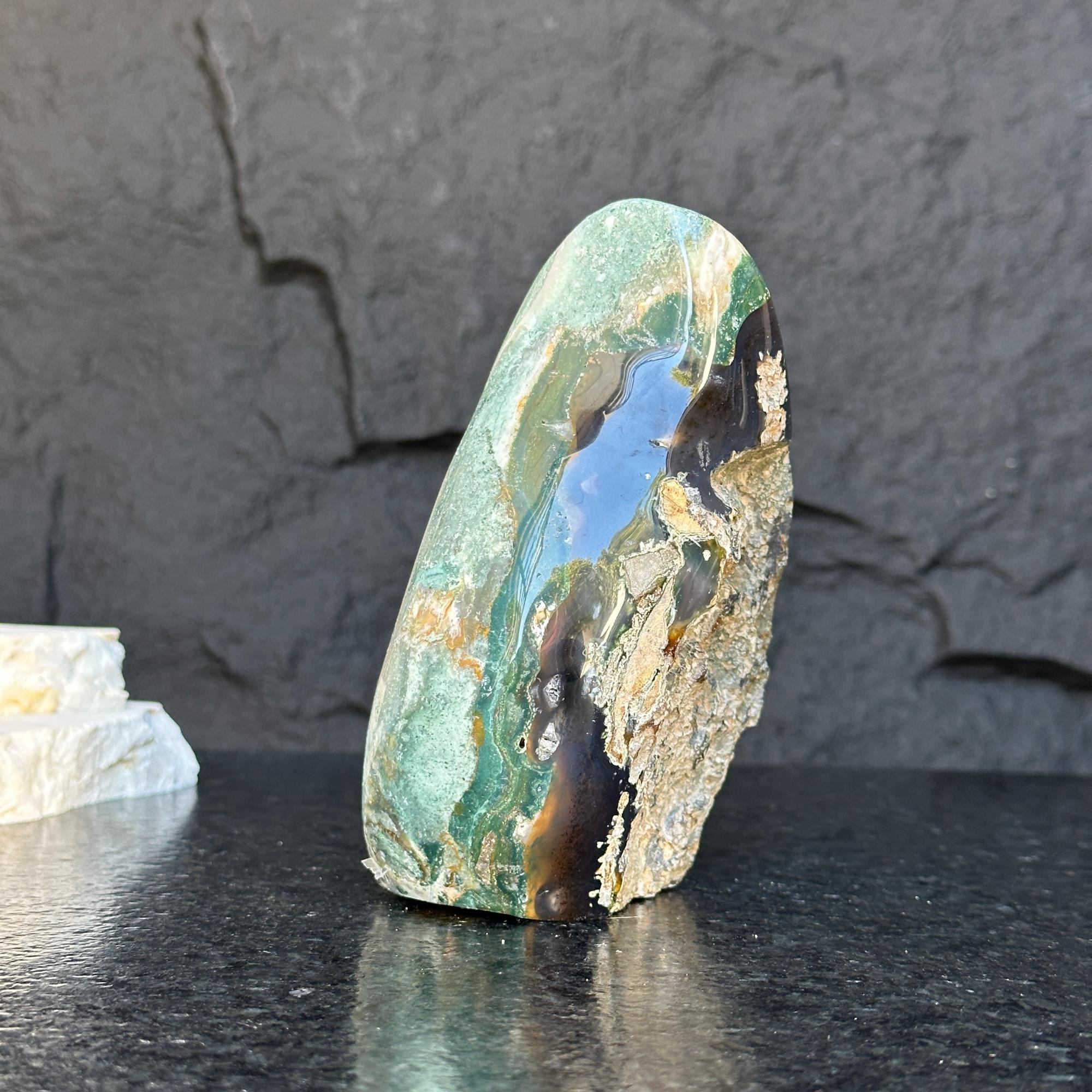 Polished green jasper flame gemstone, 5.5-inch tall, with natural brown and black inclusions.