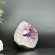 Deep purple amethyst geode egg, polished oval crystal with natural agate bands and sparkling points.