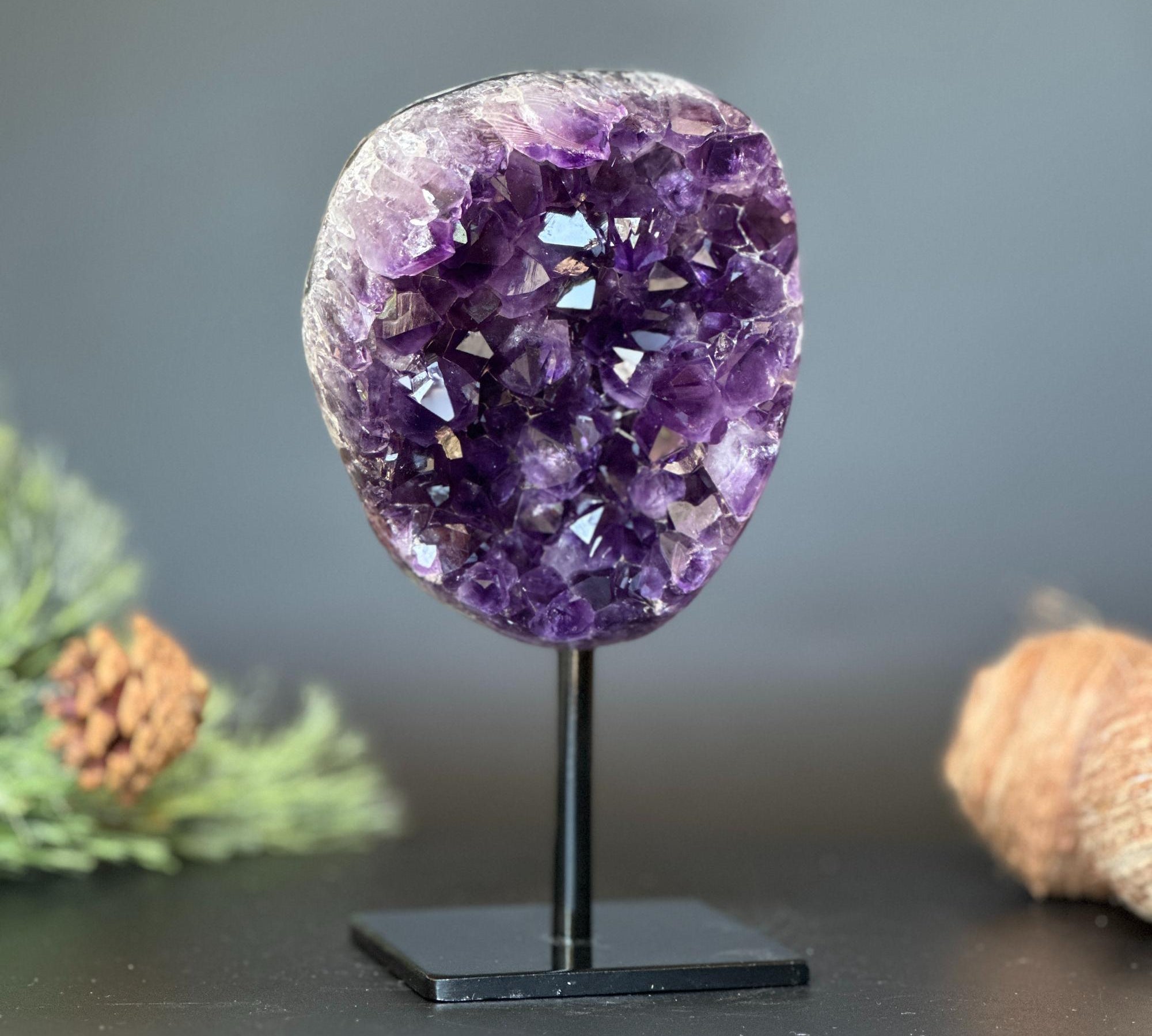 Deep purple Uruguayan amethyst geode on a black metal stand, 7 inches tall.