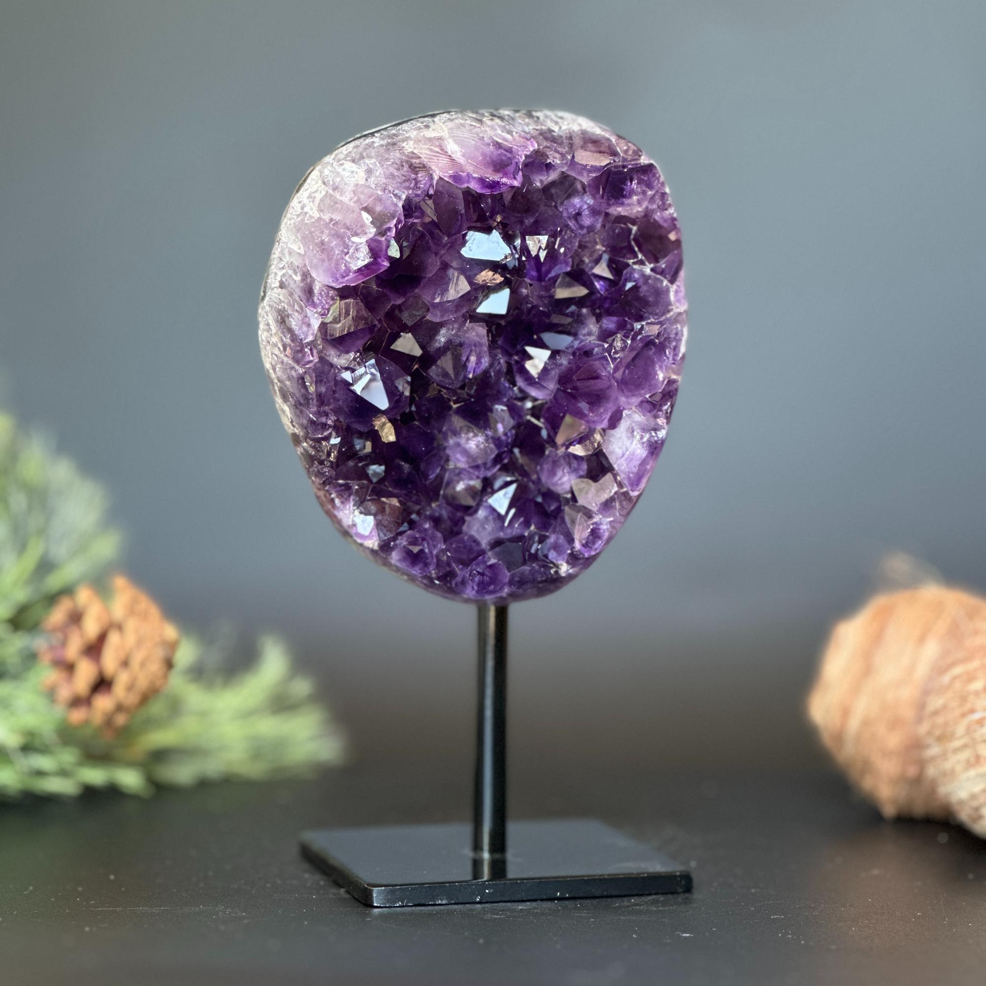 Deep purple Uruguayan amethyst geode on a black metal stand, 7 inches tall.