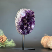 Deep purple Uruguayan amethyst geode, 7-inch tall crystal cluster on a black stand.