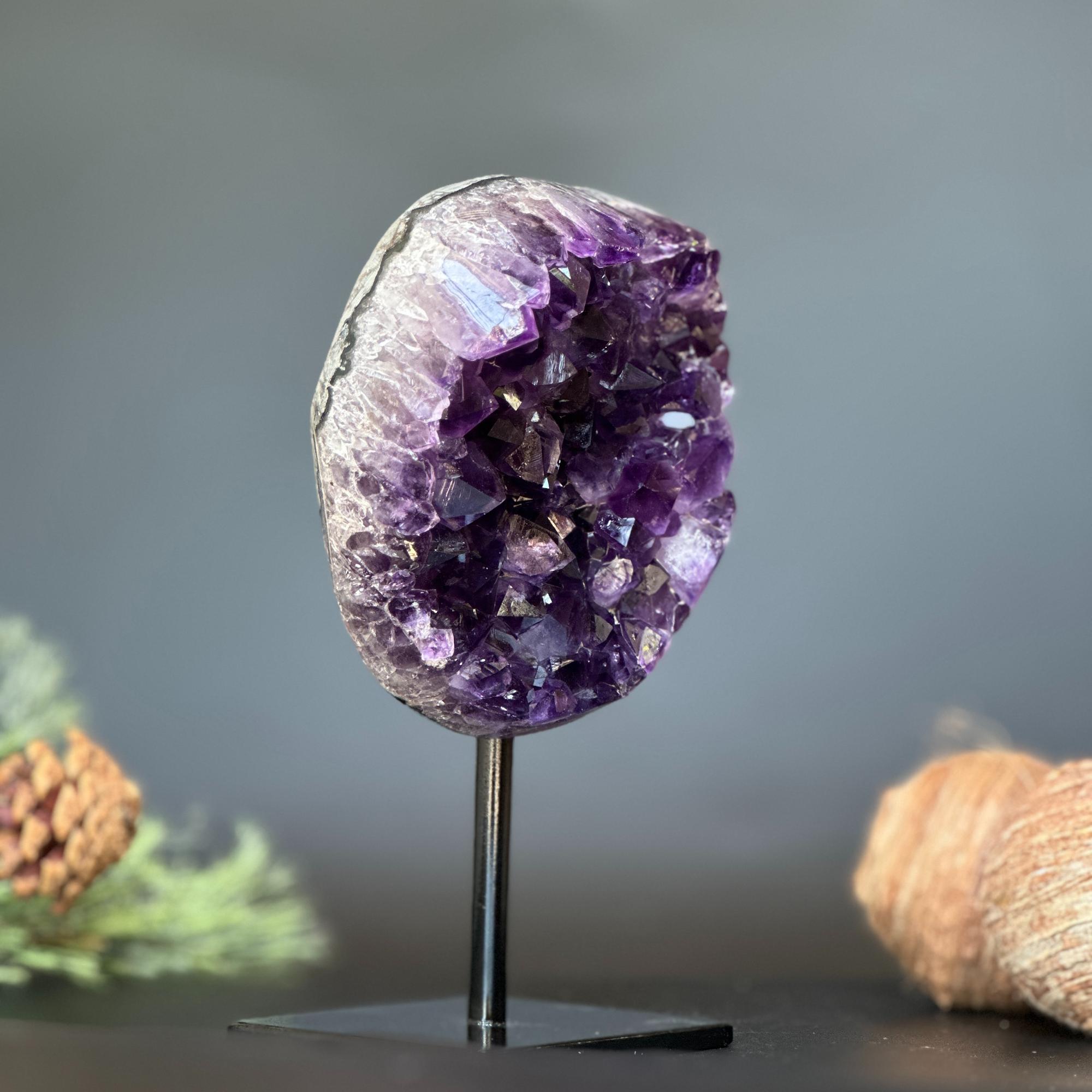 Deep purple Uruguayan amethyst geode, 7-inch tall crystal cluster on a black stand.