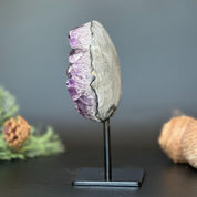 Deep purple Uruguayan amethyst geode, 7-inch tall crystal cluster on a black metal stand.