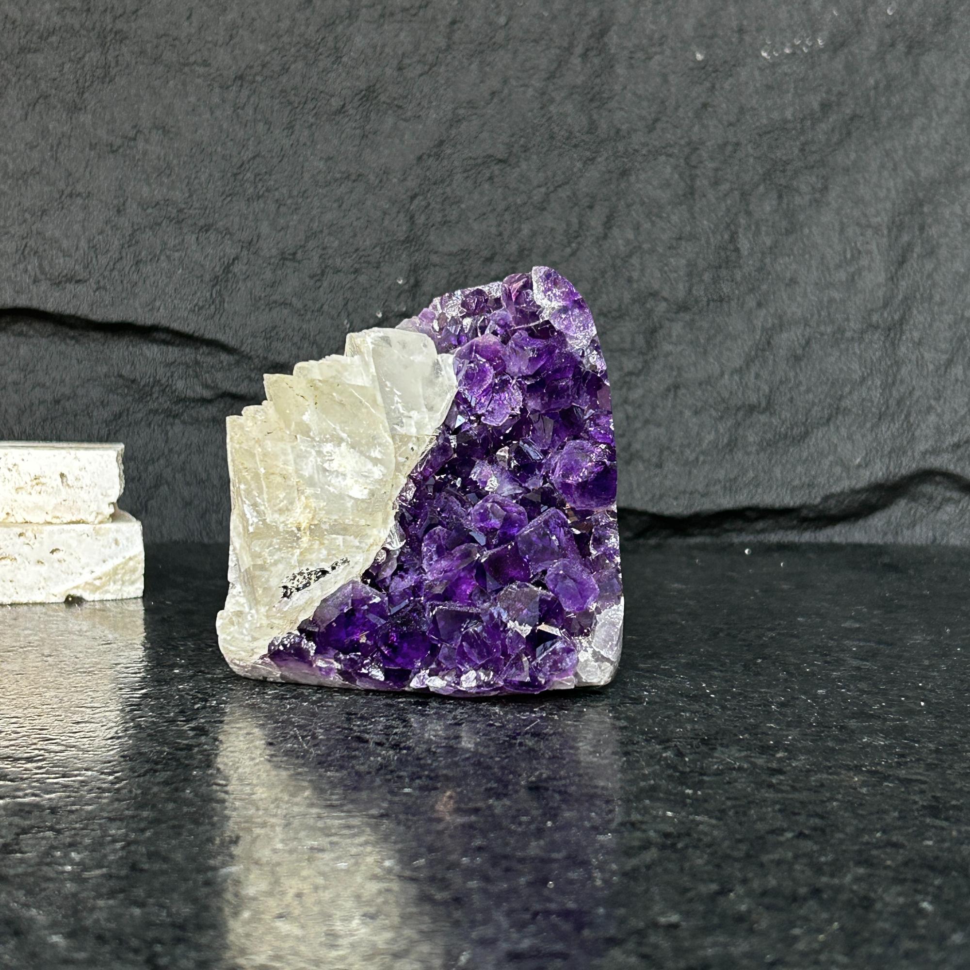 Large raw Uruguayan amethyst geode cluster with deep purple crystals and white rock.