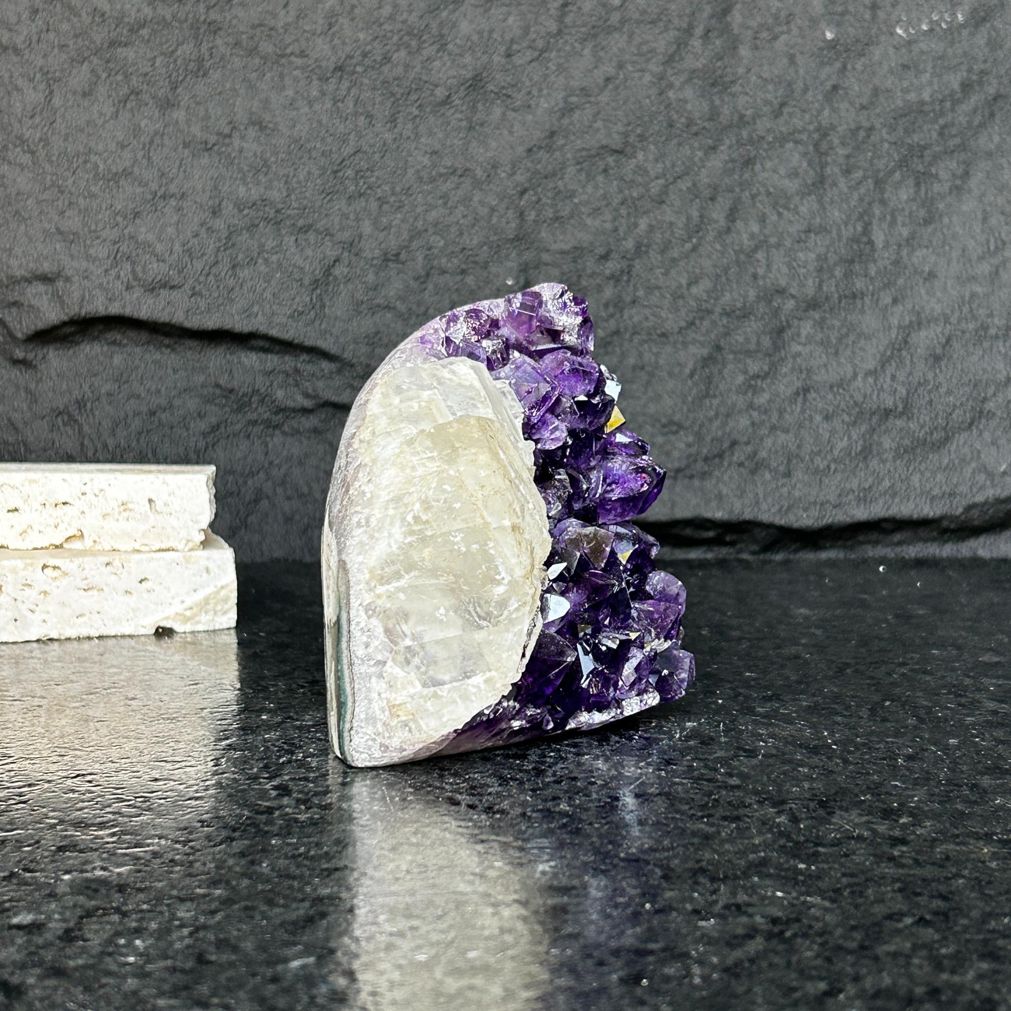 Large raw Uruguayan amethyst geode cluster with deep purple crystals and natural stone backing.