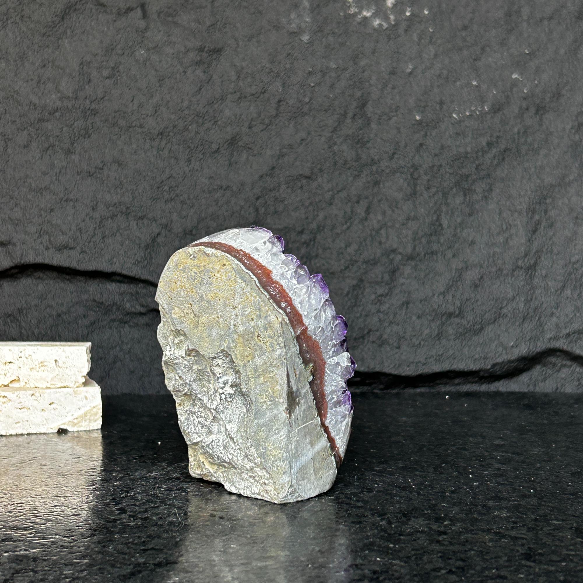 Large Uruguayan amethyst geode with deep purple crystals and a natural grey and reddish-brown rock exterior.