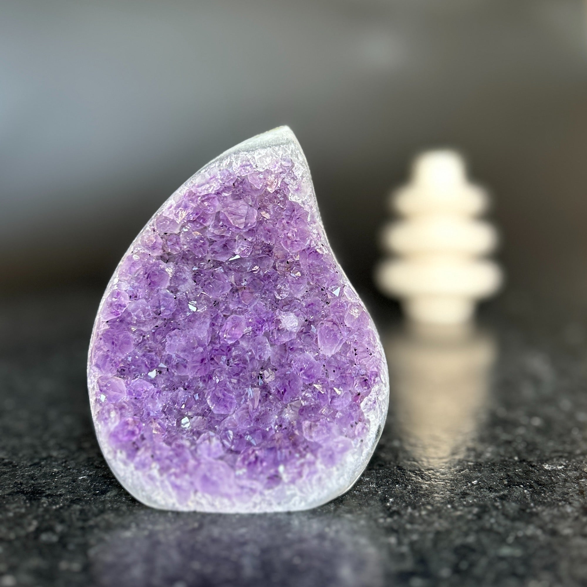 Large, teardrop-shaped natural amethyst crystal with deep purple druzy and polished edges.