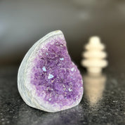 Large, polished amethyst crystal geode with vibrant purple druzy, shaped like a flame.