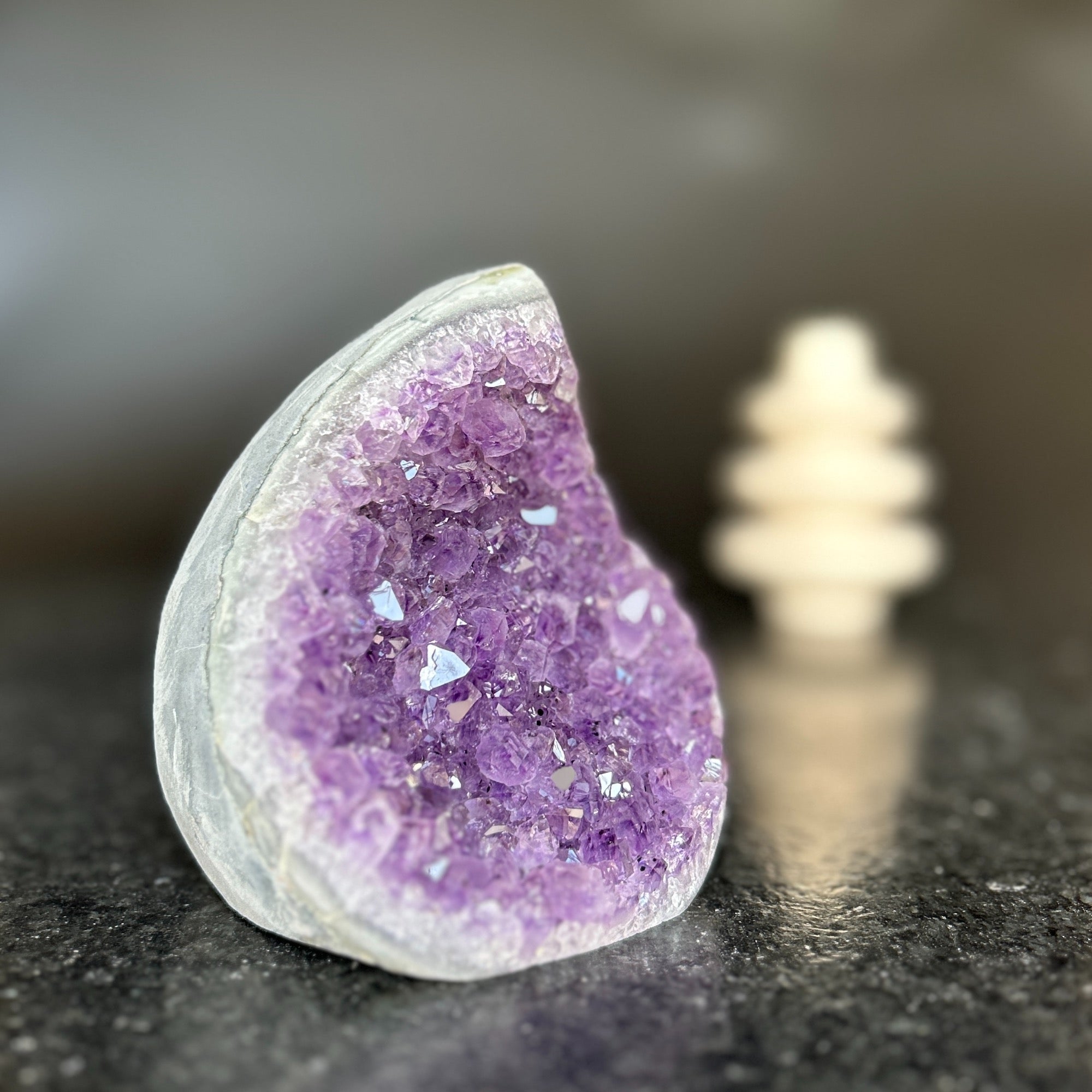 Large, polished amethyst crystal geode with vibrant purple druzy, shaped like a flame.