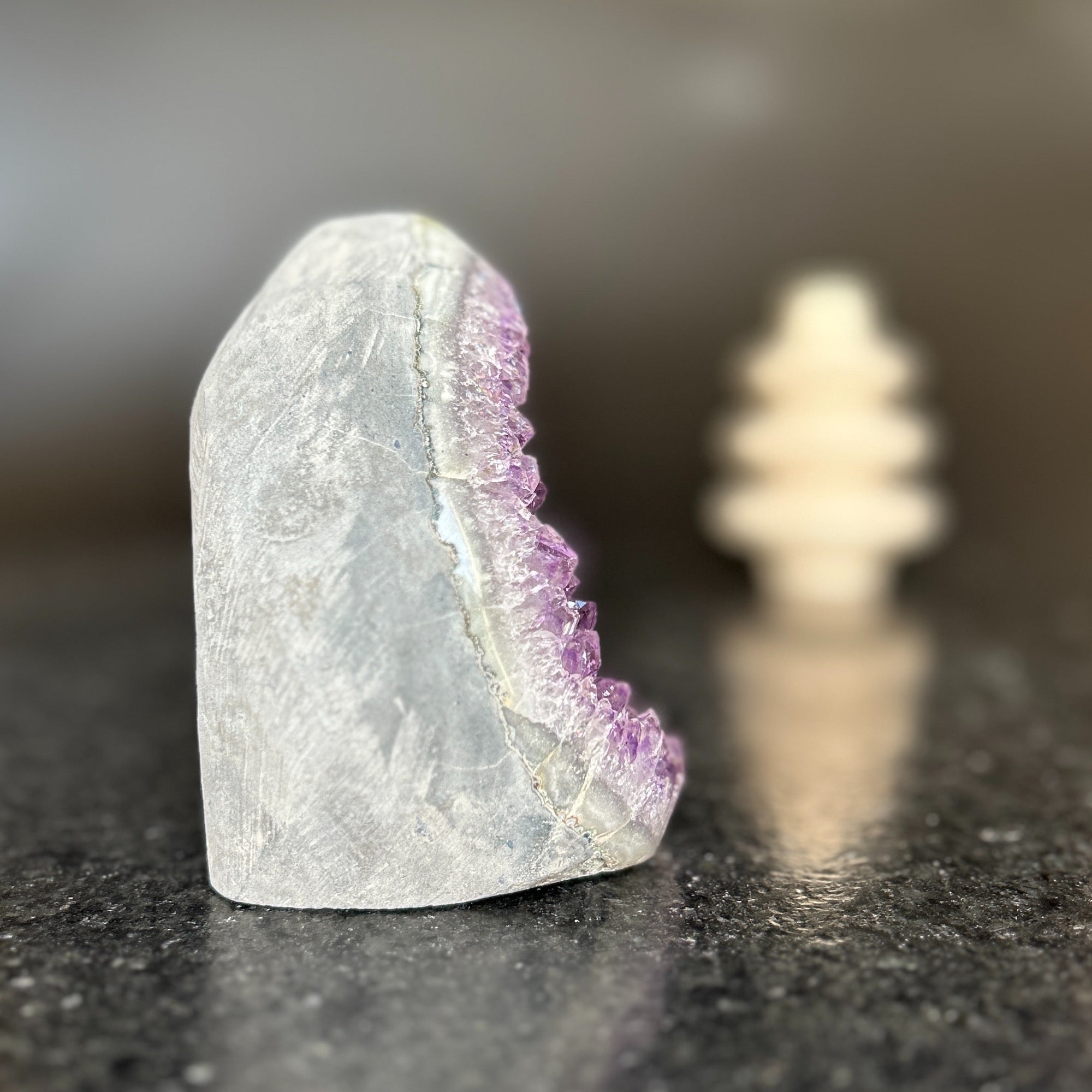 Large natural amethyst crystal geode with deep purple druzy, polished edges, and gray exterior.