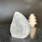 Large, natural amethyst crystal flame stone, polished smooth, with a subtle purple hue.