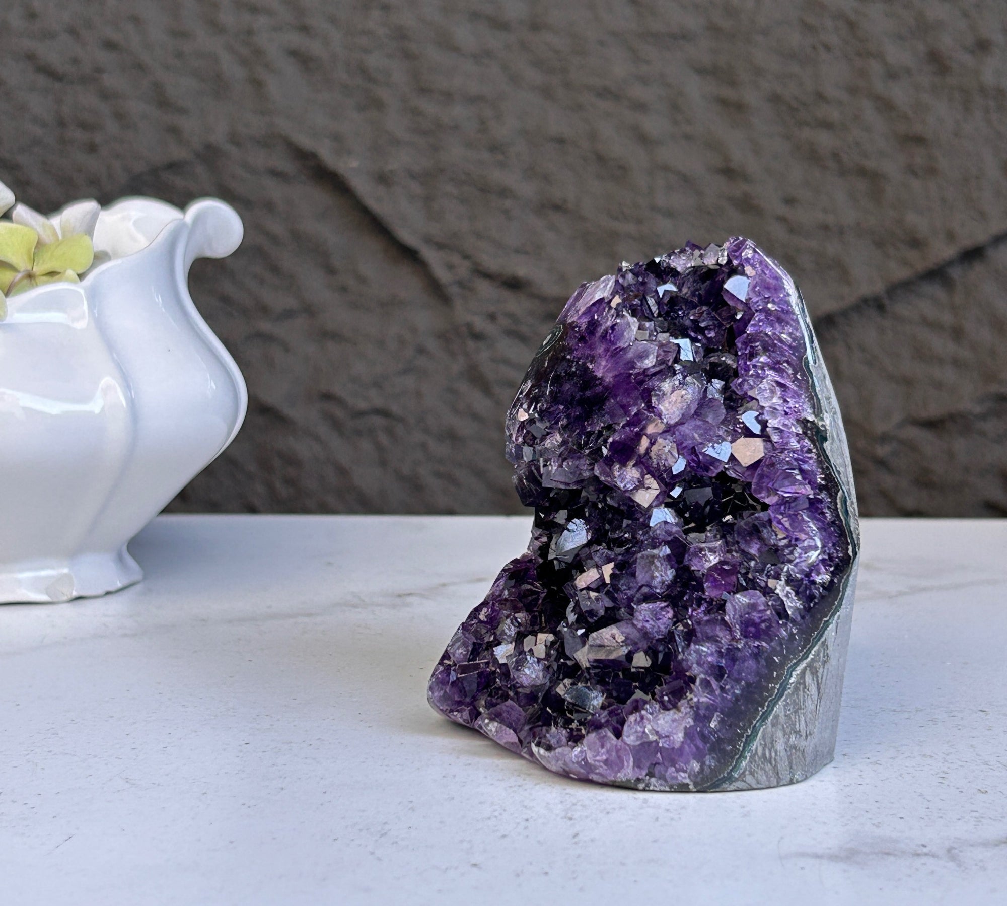 Large deep purple amethyst geode crystal cluster with sparkling formations.